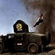An explosion hits near a vehicle belonging to Iraq's elite Rapid Response Division on February 25, 2017, during the assault to retake the western half of Mosul, which is still occupied by Islamic State group jihadists