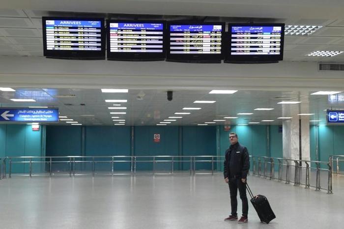 A tourist looks at lists of cancelled flights at the international airport in Tunisia's capital on January 17, 2019