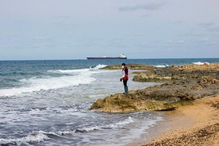 A Libyan Red Crescent volunteer looks for bodies in February 2017
