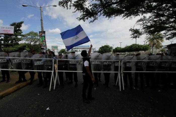 An activist waves a national flag during a march against the construction of the Interoceanic Grand Canal and denouncing what they claim to be electoral fraud in the November 6 elections Nicaragua, in Managua on December 1, 2016