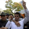 This photo taken on February 18, 2014 shows Venezuelan opposition leader Leopoldo Lopez (R) as he is escorted by the National Guard after turning himself in, during a demonstration in Caracas