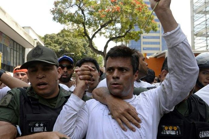This photo taken on February 18, 2014 shows Venezuelan opposition leader Leopoldo Lopez (R) as he is escorted by the National Guard after turning himself in, during a demonstration in Caracas