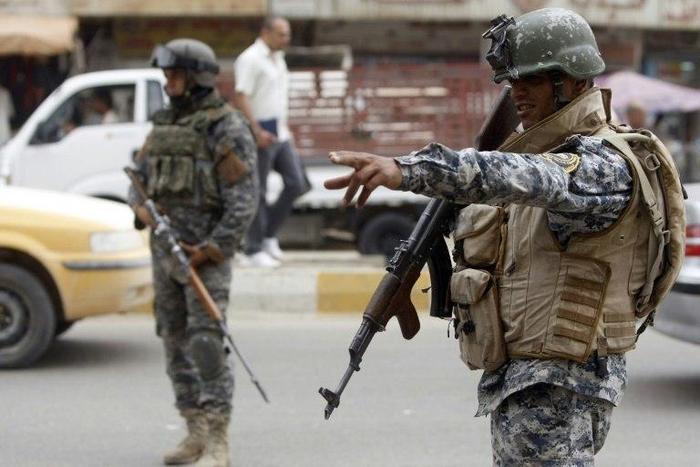 Iraqi security forces patrol a Baghdad street