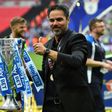 Huddersfield Town's head coach David Wagner gestures as he holds the Championship Playoff trophy on the pitch after winning the penalty shoot-out in the English Championship play-off final football match against and Reading