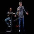 People sit near an hologram of French presidential election candidate Jean-Luc Melenchon (C) during a campaign meeting on February 5, 2017 in La Plaine Saint Denis, northern Paris