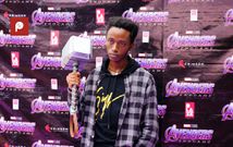 Marvel fan taking a pose with Thor's hammer