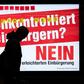 A man walks past an electoral poster by the Committee against Facilitated Naturalization/Citizenship reading "Uncontrolled Naturalisation? No" featuring a woman wearing a niqab, in a train station in Zurich, on February 7, 2017