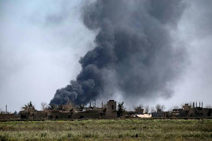 Black smoke billows during battles between the US-backed Syrian Democratic Forces and holdout jihadists of the Islamic State group in the village of Baghouz near Syria's border with Iraq