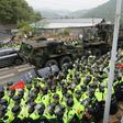 Protesters and police gather to watch as trailers carrying US THAAD missile defence equipment enter a deployment site in Seongju, South Korea