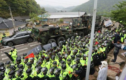 Protesters and police gather to watch as trailers carrying US THAAD missile defence equipment enter a deployment site in Seongju, South Korea