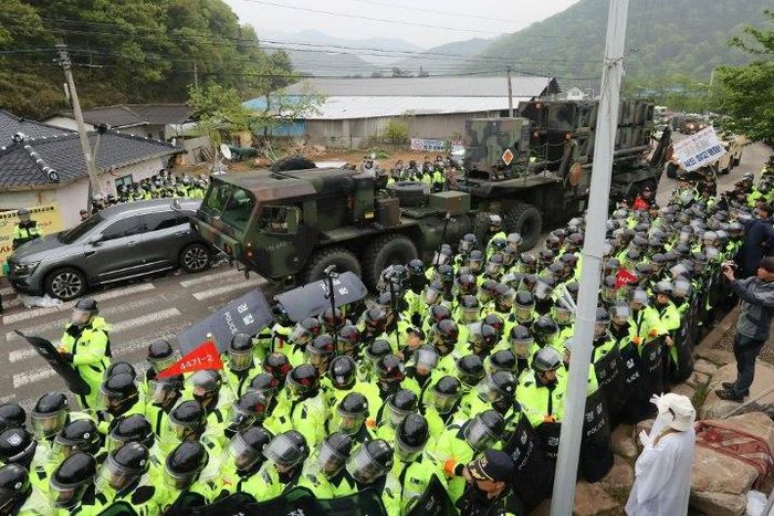 Protesters and police gather to watch as trailers carrying US THAAD missile defence equipment enter a deployment site in Seongju, South Korea