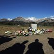 This file photo taken on April 6, 2015 shows people's shadows as they stand near a stela commemorating the victims of the March 24 Germanwings Airbus A320 crash in the village of Le Vernet, southeastern France, after a ceremony with victims' relatives.
