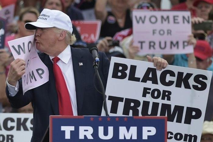 File photo shows then Republican presidential nominee Donald Trump kissing a "Women for Trump" placard during a rally in Florida
