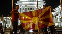 Protesters wave a Macedonian flag in front of the government building in Skopje on April 18, 2016, during a protest against the president's shock decision to halt probes into more than 50 public figures embroiled in a wire-tapping scandal