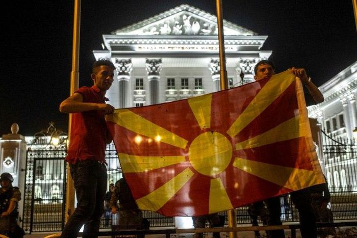 Protesters wave a Macedonian flag in front of the government building in Skopje on April 18, 2016, during a protest against the president's shock decision to halt probes into more than 50 public figures embroiled in a wire-tapping scandal