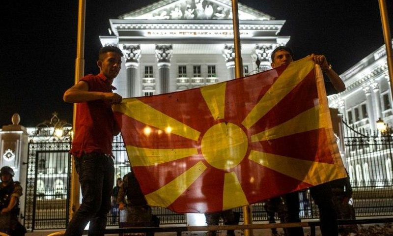 Protesters wave a Macedonian flag in front of the government building in Skopje on April 18, 2016, during a protest against the president's shock decision to halt probes into more than 50 public figures embroiled in a wire-tapping scandal