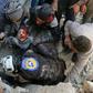 Syrian civil defence volunteers, known as the White Helmets, rescue a boy from the rubble following an attack on the Bab al-Nairab neighbourhood of Aleppo on November 24, 2016