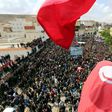 Tunisians wave the national flag during a general strike in the southern city of Tatouine on April 11, 2017