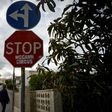People pass by a stop sign that was vandalised with the message "STOP McCann Circus" in the Portuguese town of Praia da Luz where British girl Madeleine McCann disappeared 10 years ago