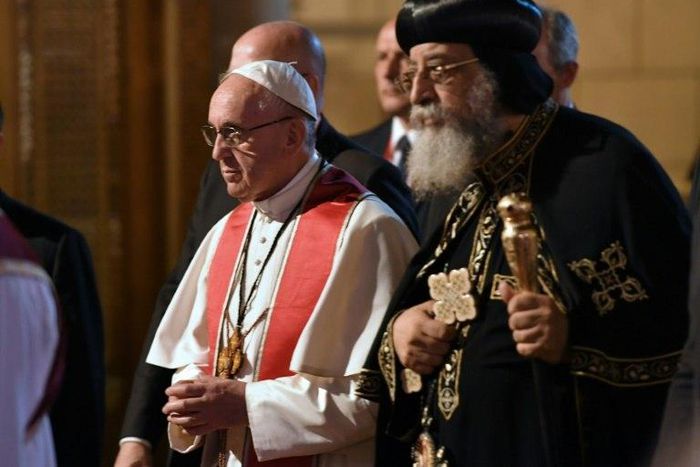 Pope Francis (L) walks alongside Coptic Pope Tawadros II (R) during a visit to Cairo on April 28, 2017