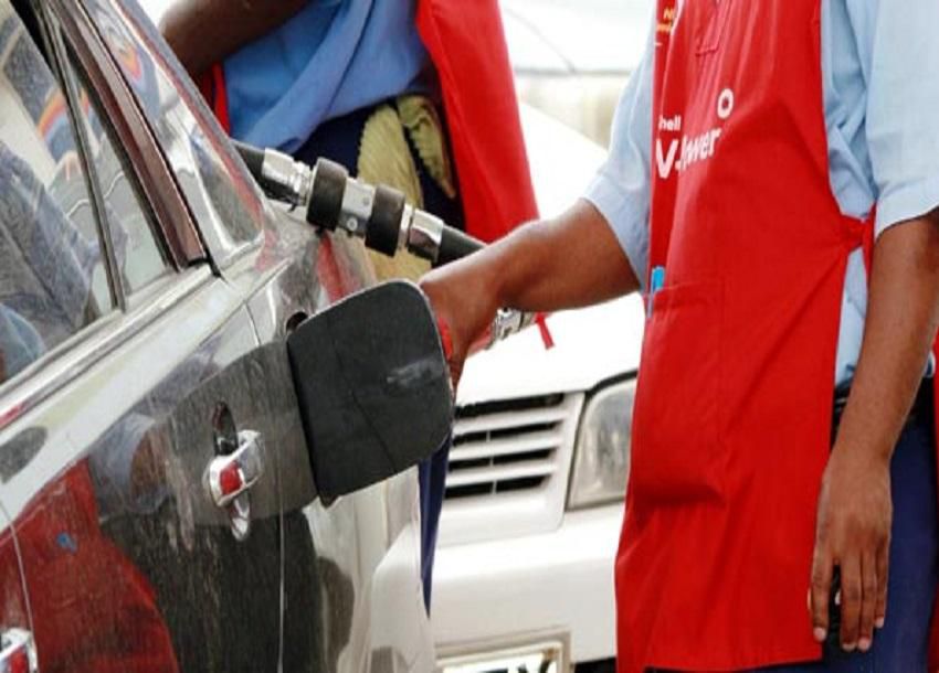 A petrol station attendant fuelling a car