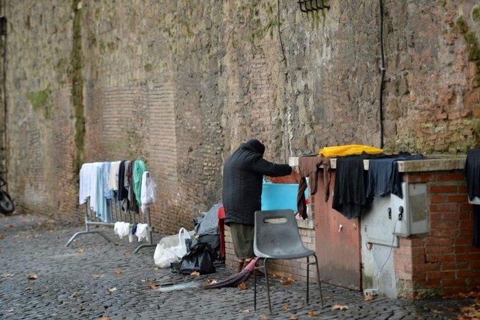 A homeless women does her laundry where she lives near the Vatican, which announced the opening of a free launderette for the poor and homeless