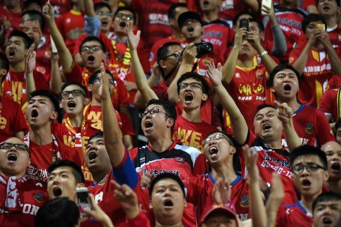 Fans of China's Guangzhou Evergrande chant slogans at supporters of Hong Kong's Eastern during an AFC Champions League football match between the two sides in Hong Kong
