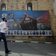 File picture of a man running past a poster of Palestinian hunger-striker and prominent prisoner Marwan Barghouti in the West Bank city of Ramallah on May 3, 2017