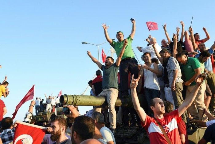 Turkish pro-regime activists celebrate after seizing a tank in Istanbul, during the failed July 15 coup in which 300 people were killed