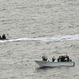 Search and seizure team members (L) from the USS Vella Gulf close in to apprehend suspected pirates (R) in the Gulf of Aden in 2009