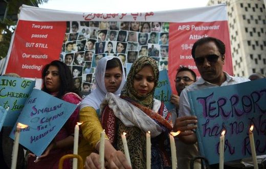 Residents of Karachi hold lighted candles during a ceremony on December 16, 2016, as they pay tribute to victims on the second anniversary of an attack on The Army Public School in the northwestern city of Peshawar Parents of children killed when Talib...