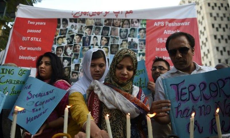 Residents of Karachi hold lighted candles during a ceremony on December 16, 2016, as they pay tribute to victims on the second anniversary of an attack on The Army Public School in the northwestern city of Peshawar Parents of children killed when Talib...