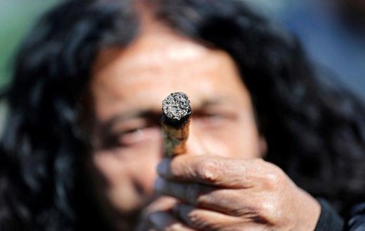 An Israeli smokes a marijuana joint in Jerusalem on April 20, 2017 during a rally to express their defiance of current laws