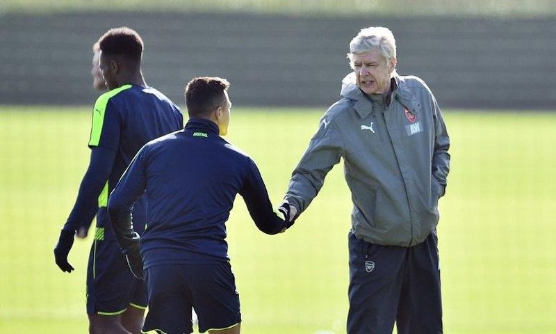 Arsenal manager Arsene Wenger (right) shakes hands with Chilean striker Alexis Sanchez during a training session in London Colney, on March 6, 2017