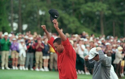 Tiger Woods raises his arms in victory after winning the 1997 Masters tournament, a turning point for the sport, the man and even the course