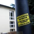 A sticker reading 'Please keep on fleeing - here is no place for you - refugees not welcome' is pinned at a lantern next to a refugee centre in Freital, eastern Germany