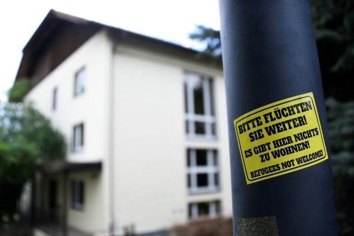 A sticker reading 'Please keep on fleeing - here is no place for you - refugees not welcome' is pinned at a lantern next to a refugee centre in Freital, eastern Germany