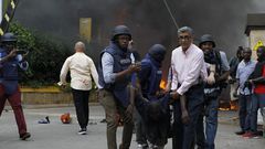 Journalists and foreign security officials help a survivor (Twitter)