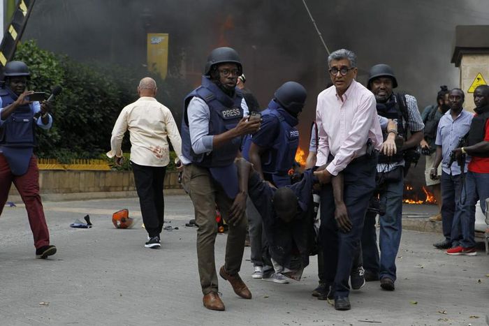 Journalists and foreign security officials help a survivor (Twitter)