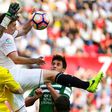 Sevilla's Clement Lenglet (C) jumps for the ball with Leganes' Iago Herrerin during their match in Sevilla on March 11, 2017