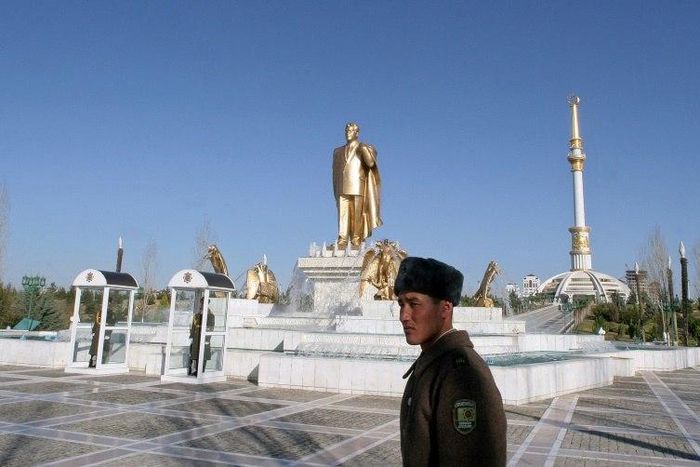 Soldiers stand guard near a golden statue of Turkmenistan's first president Saparmurat Niyazov in the capital Ashgabat