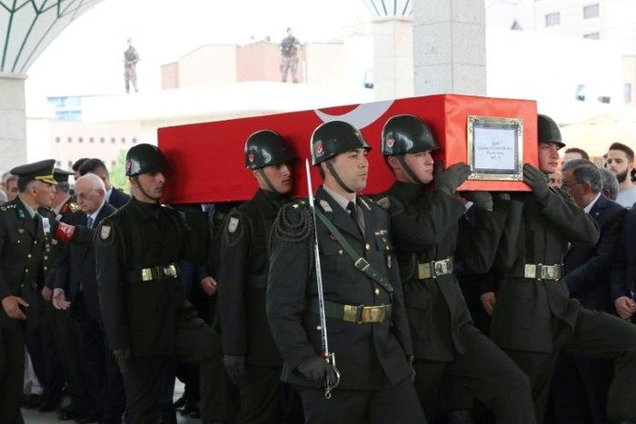 Turkish soldiers carry the coffin of Colonel Oguzhan Küçükdemirkol who was among 13 killed in the helicopter crash