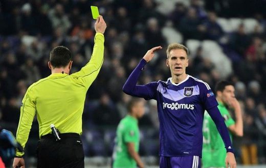 Anderlecht's forward Lukasz Teodorczyk (R) reacts after receiving a yellow card during the UEFA Europa League football match against Saint-Etienne December 8, 2016