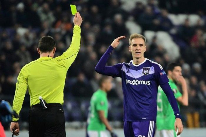 Anderlecht's forward Lukasz Teodorczyk (R) reacts after receiving a yellow card during the UEFA Europa League football match against Saint-Etienne December 8, 2016