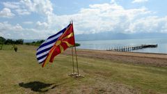 The flags of Greece and Macedonia flutter on the shores of Lake Prespa where last June's historic name deal was signed