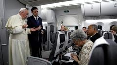 Pope Francis, flanked by Vatican spokesman Alessandro Gisotti (right) anwers journalists questions in the plane following the take off from Panama City on January 27, 2019 after participating in World Youth Day
