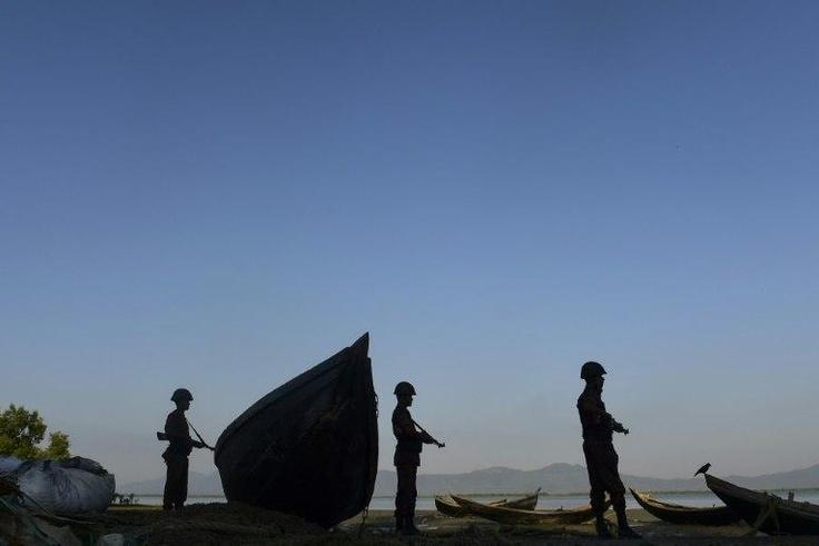 Bangladesh soldiers stand guard as they try to stop the illegal entry of Myanmar Rohingya refugees on the banks of the Naf River