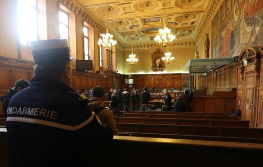 A gendarme looks towards reporters in the courtroom of a Special Court of Assizes at the Paris courthouse, prior to the start of the trial of a jihadist network known as the "Cannes-Torcy cell", on April 20, 2017