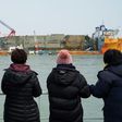 Relatives of the missing from the Sewol ferry disaster look at the damaged ferry during a memorial service from a ship off the coast of the southern South Korean island of Jindo on March 28, 2017