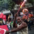 A protester holds fireworks during a demonstration against the Brazilian government's social welfare reform bill in Rio de Janeiro, on March 15, 2017